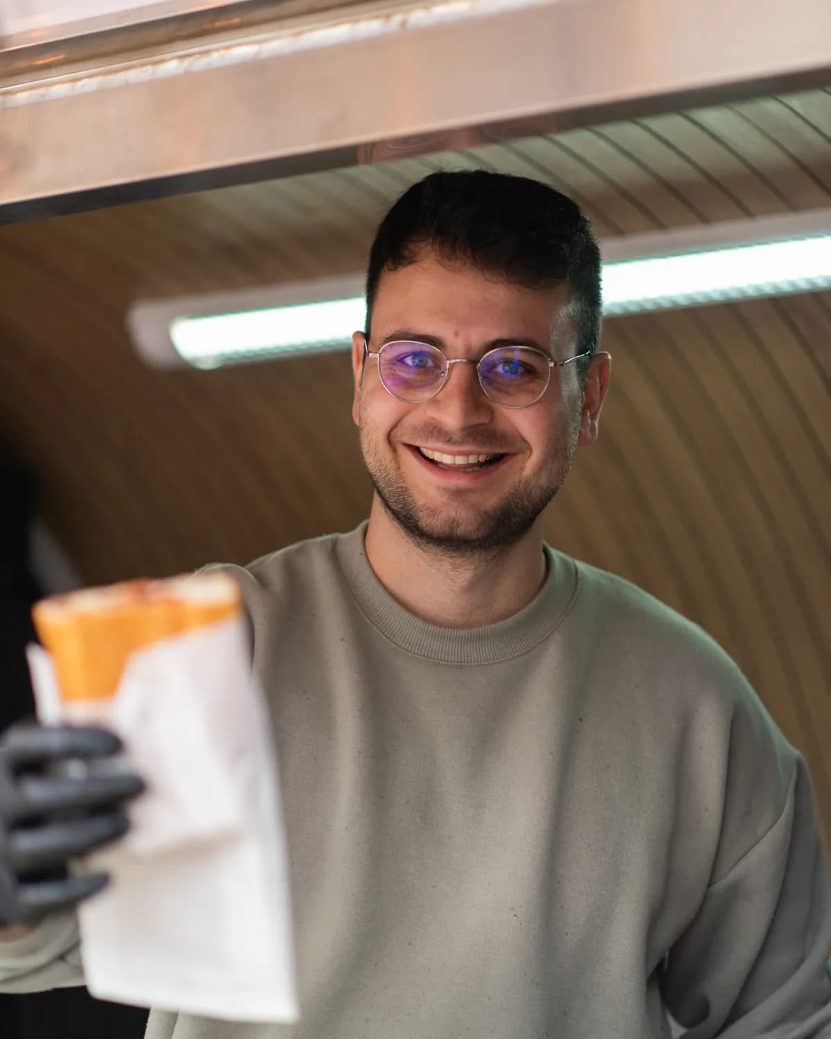 Furkan Suv, Gründer von MAT Köfte, lächelnd im Truck mit einem frisch eingepackten Köfte