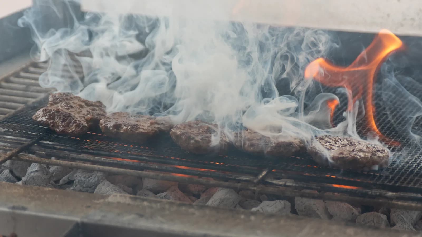 Köfte über offener Flamme und Rauch auf dem Grill im Truck