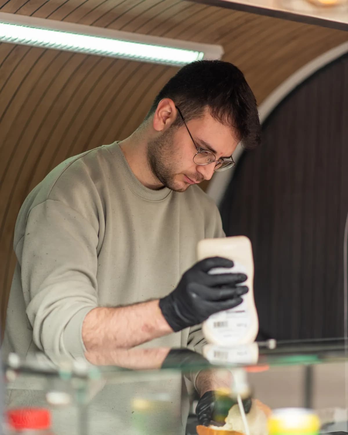 Furkan Suv, Gründer von MAT Köfte, gibt im Truck Sauce aufs Köfte-Brot