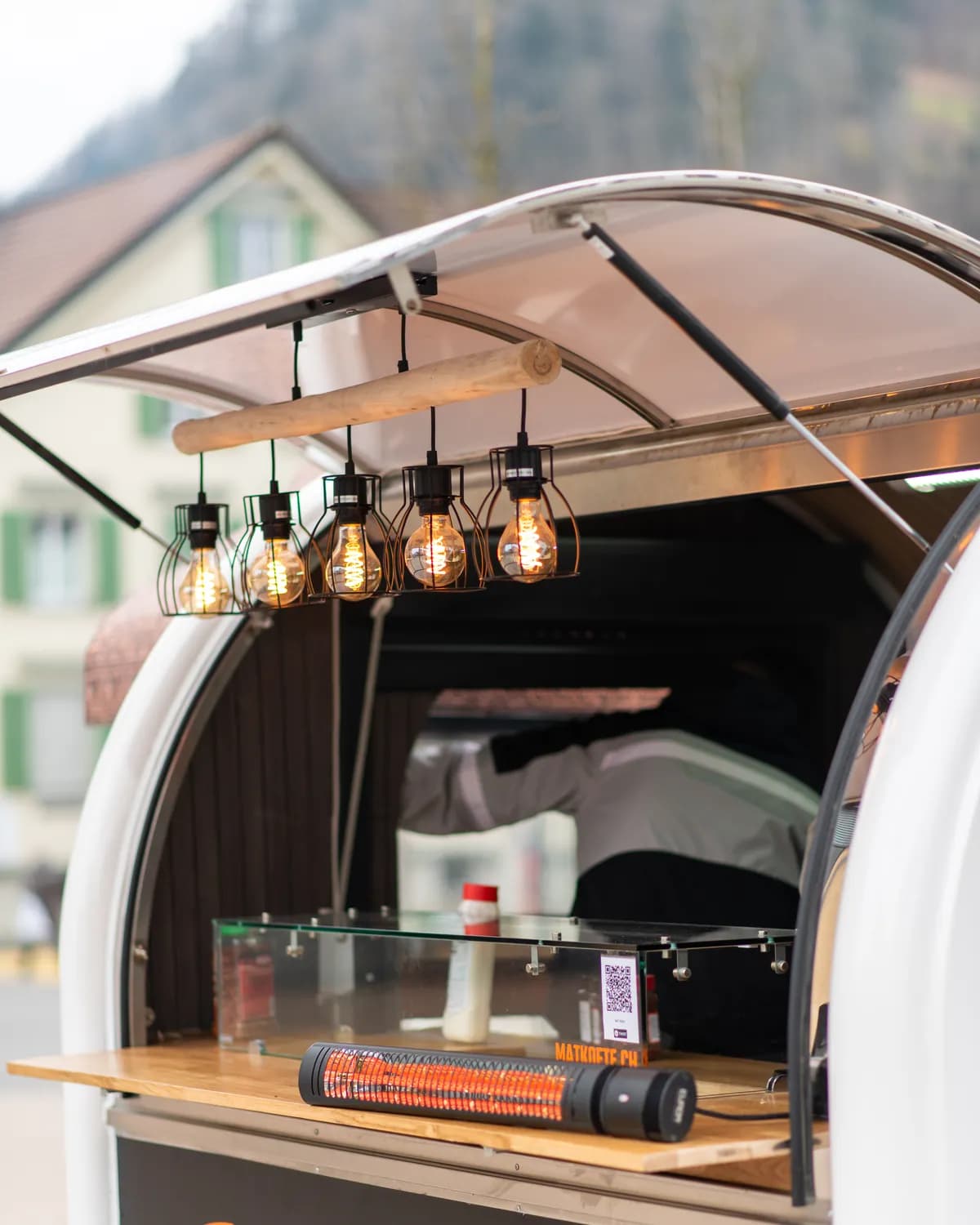 Der MAT Köfte Truck mit offener Klappe, warmen Glühbirnen und Holztheke